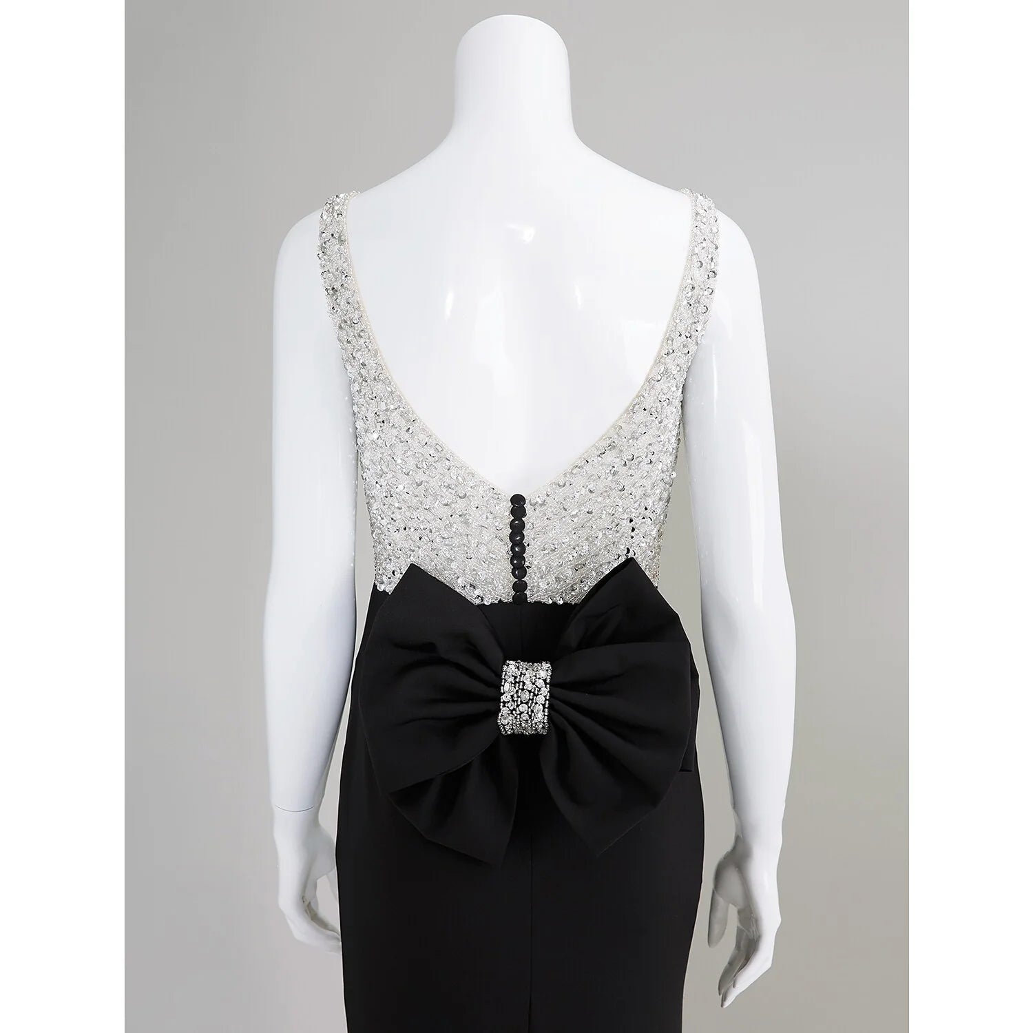 Detail of the elegant bows and beading embellishments on the dress.