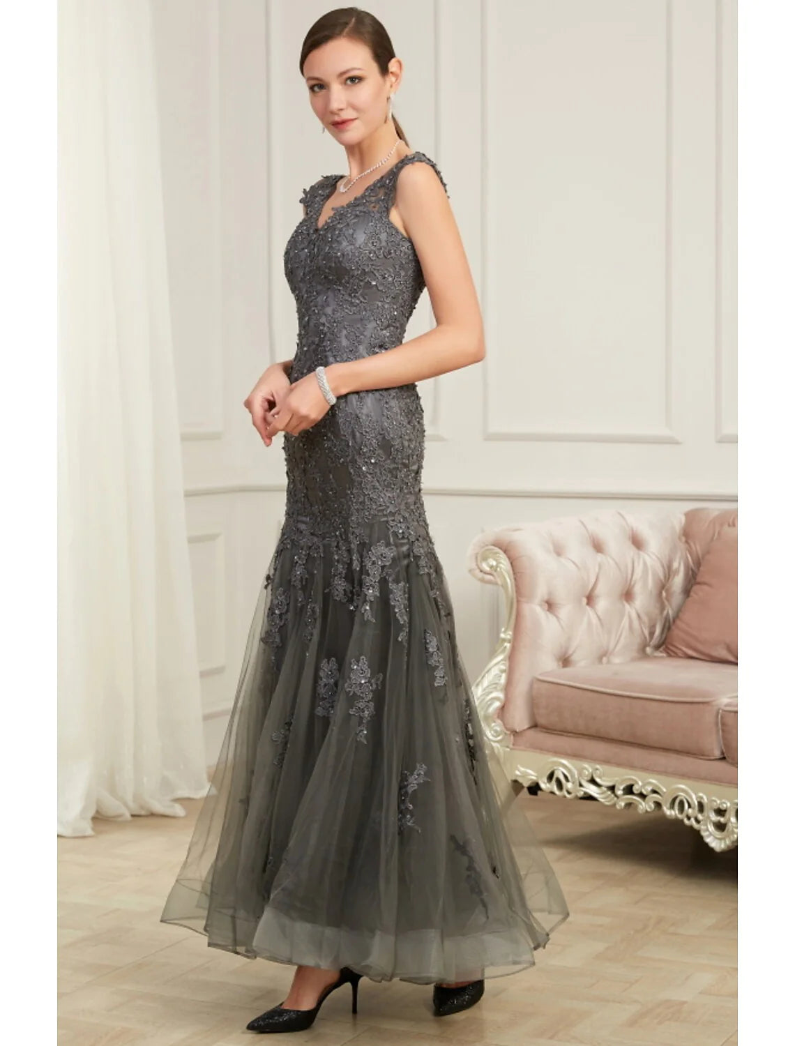 Woman in a sparkling sequin mermaid V-neck evening gown, front view.