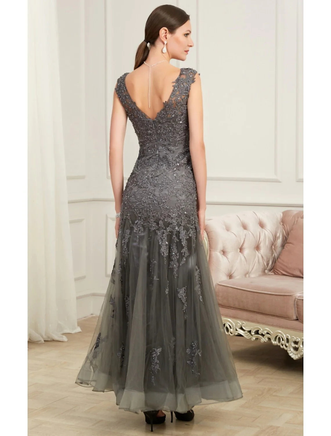 Woman in a sparkling sequin mermaid V-neck evening gown, side view.