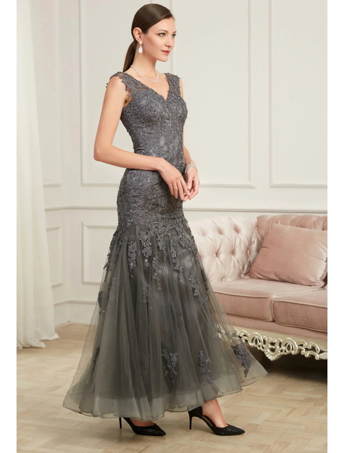Woman in a sparkling sequin mermaid V-neck evening gown, back view.