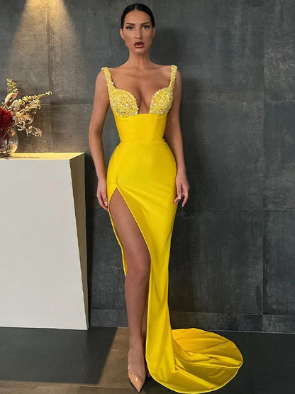 Model wearing a sparkling yellow sequin V-neck long prom dress, front view.