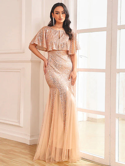 Woman in sparkling two-piece mermaid prom dress with sequin shawl, front view.