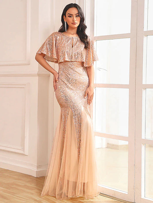 Woman in sparkling two-piece mermaid prom dress with sequin shawl, front view.