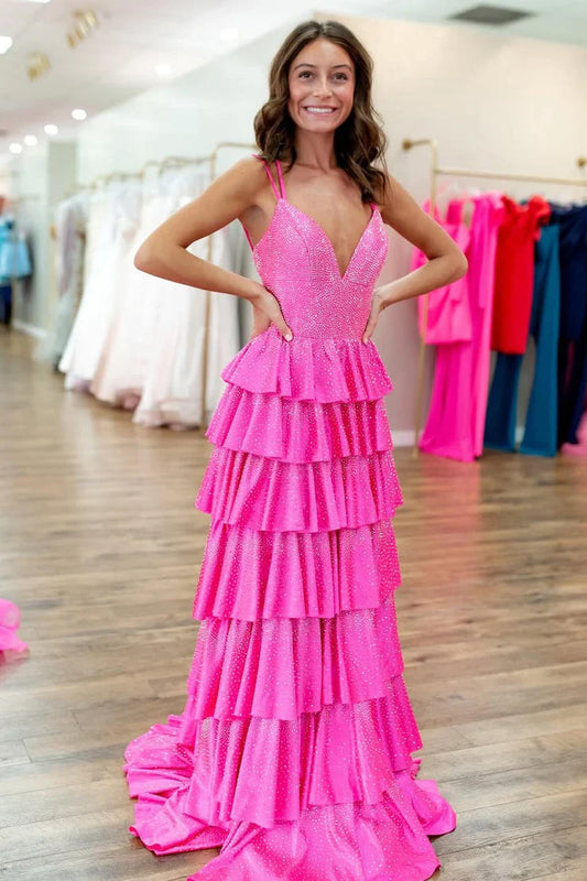 A model wearing a sparkly pink A-line V-neck tiered prom dress with hot stone embellishments.
