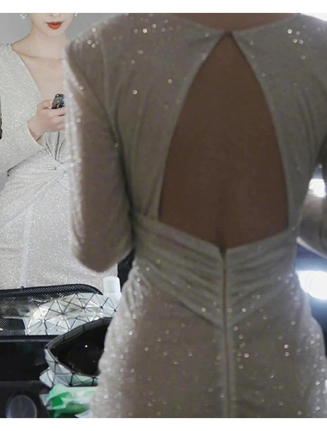 Back view of a woman in a sequined long sleeve homecoming dress.