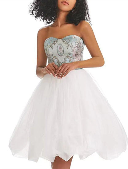 A woman standing in a vibrant A-line strapless color block tulle print short dress, side view.