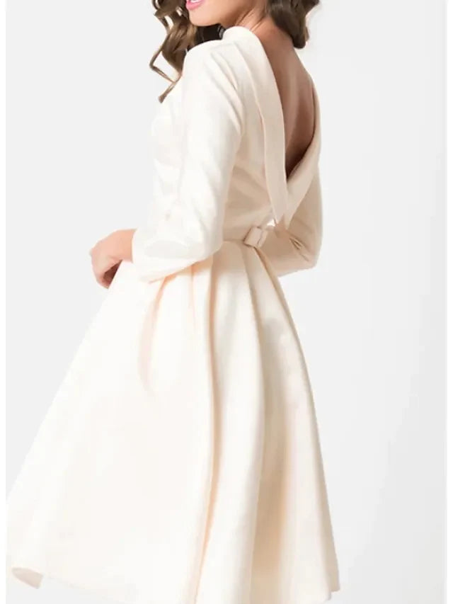 Side view of the white A-line knee-length wedding dress, highlighting the draping detail.