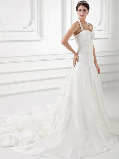 Elegant A-Line halter neck wedding dress with court train and ruched beading.